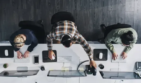 Équipe de support informatique externalisé travaillant sur postes de travail